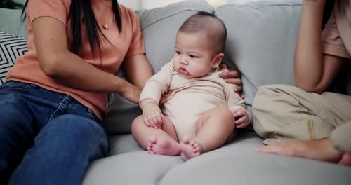 Loving family playing with baby on couch