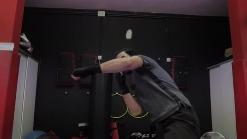 Man with facemask trains kick boxing in front of the camera and spins in a circle