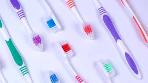 Background Dental Toothbrushes of Different Colors on a White Background Top View