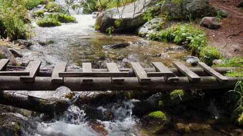 Wooden Bridge Across Mountain River in Slow Motion