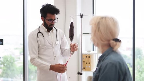Hombre experimentado en bata de laboratorio probando un gotero con sangre para transfusiones