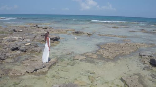 Beautiful bride in wedding dress walks tropical beach in Mexico aerial drone view