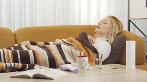 Une femme malade qui éternue se couche.