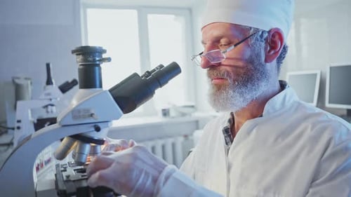 Wissenschaftler analysieren Probe mit Mikroskop im Labor