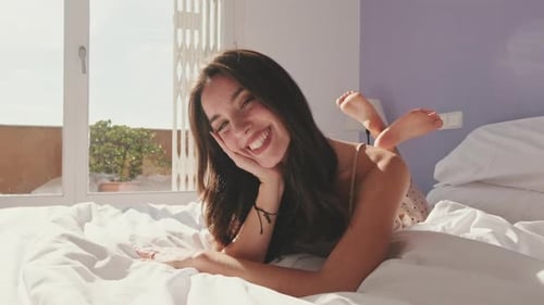 Close-up, happy girl posing lying in bed