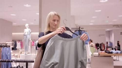 Beautiful smiling shopping customer in clothing store,