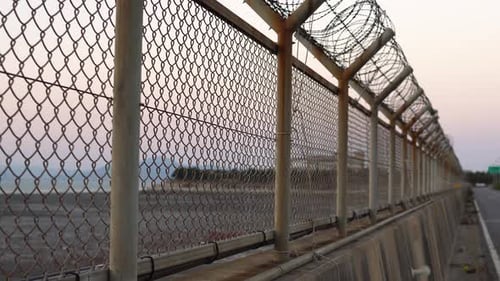 Barbed Wire Fence Along the Coast at Sunrise