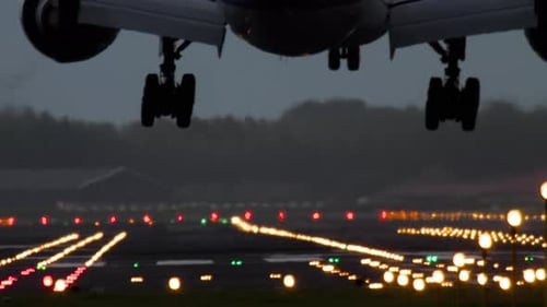 Avión aterrizando en una pista iluminada
