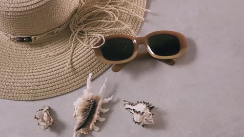 Travel planning concept. Female straw hat and sunglasses lie on beach sand