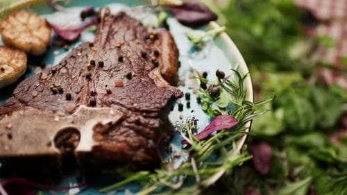 Steak d'os grillé tournant sur la table avec de la verdure fraîche