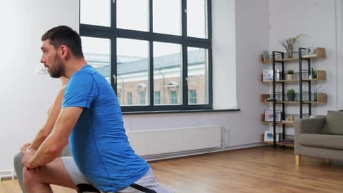 Couple Exercising and Stretching in Bright Modern Studio