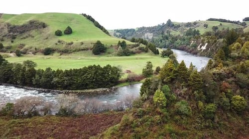 drone shot, angle rotating over river, bush and mountain in new zealand