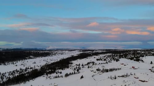 Aerial view of a snow covered village in a valley surrounded by mountains. Winter wonderland scenery