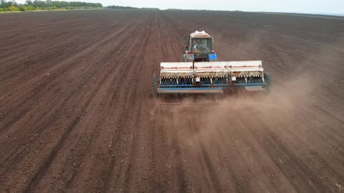 Drone Sliding Shot of a Farmer in Tractor Seeding on Sunny Day Footage of Sowing Agricultural Crops