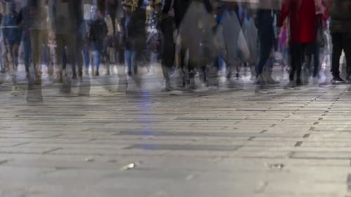 Timelapse crowd of people walking down street in evening blurred background. Nightlife of big city.