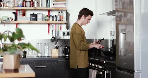 Man Cooking and using Tablet in Kitchen