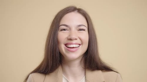 Smiling woman with long brown hair, portrait studio shot