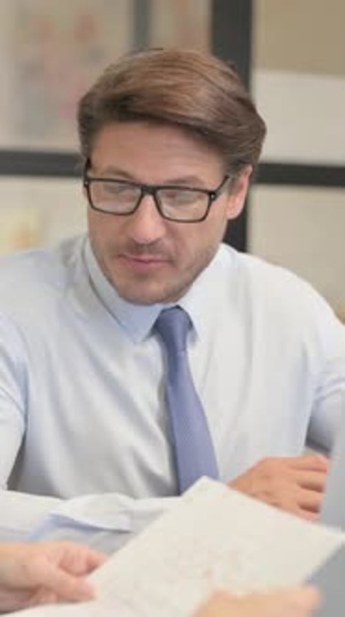 Businessman Discussing Documents in an Office Setting