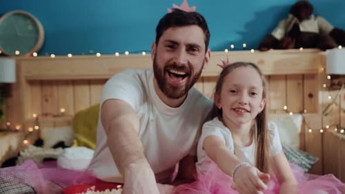 Father and Daughter in Tutus Eating Popcorn