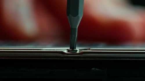 Screwdriver unscrewing small screw