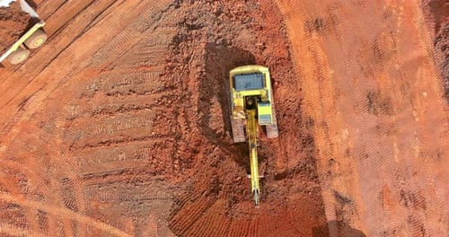 Excavator Filling Dump Truck on Construction Site Aerial