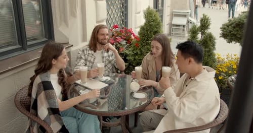 Group of Friends Talk Over Coffee at Outdoor Cafe