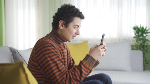Teen Relaxing on Couch Using Phone