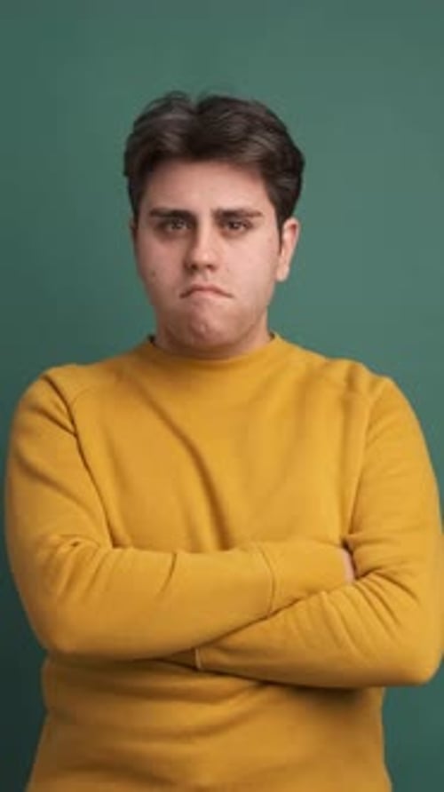 Man Making Funny Facial Expressions on Green Background