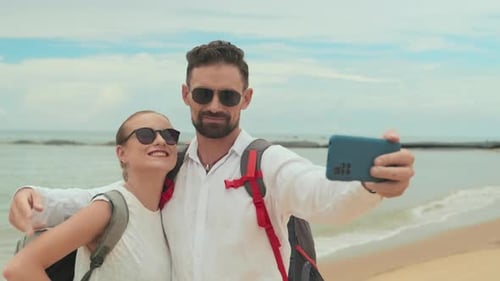 Young Affectionate Couple with Smartphone Taking Selfie on Beach