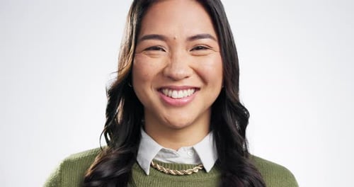 Face, smile and laughing with a cute asian woman in studio on a white background for beauty