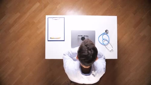 Doctor at Desk with Laptop and Medical Tools