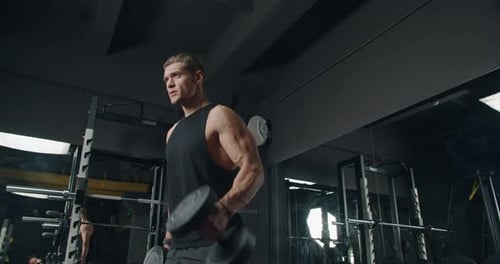 Young Athletic Man Lifting Weights in a Modern Gym