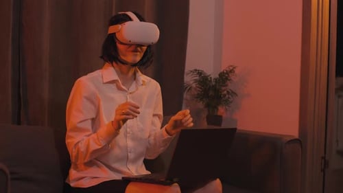 Woman Experiencing Virtual Reality on Headset and Laptop