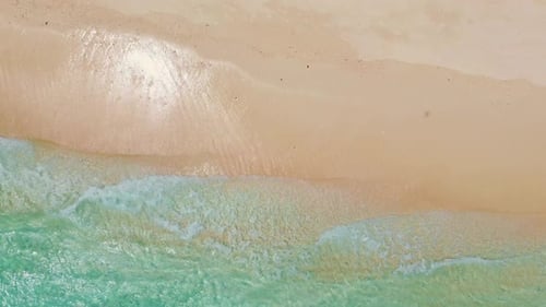 Aerial View of Waves Crashing on Sandy Beach