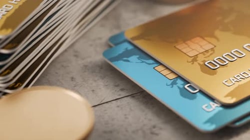 Camera movement along bank cards with gold coins. Several bank cards are stacked on a concrete table