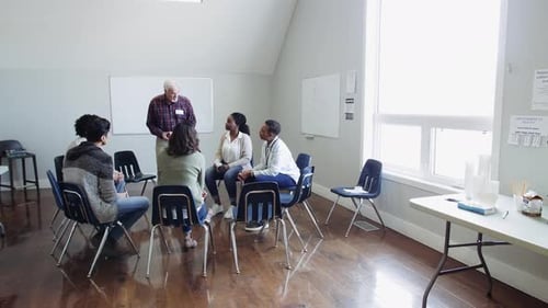 Senior man leads empathetic support group meeting at community center