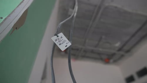 Tagged Electrical Wires Hang From Ceiling in Incomplete Hall
