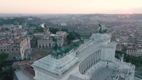 Aerial view around the statues on top of the Altare della Patria, sunset in Rome, Italy - circling,