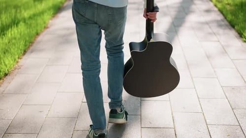 Street Performer Enjoying Walk Towards Upcoming Performance Casual Street Musician with Acoustic