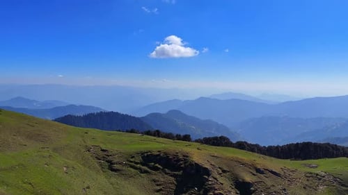 drone shot of a lush green mountain landscape , rolling hills, expansive forests