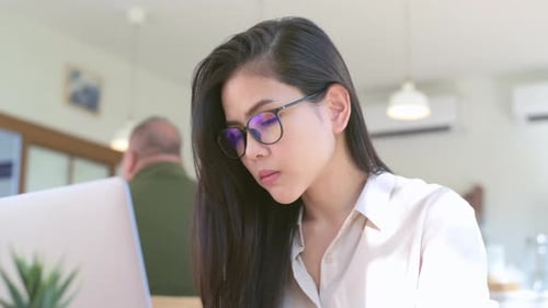 A young business woman is stressful working with laptop computer in coffee shop