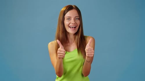 Smiling Woman Gives Thumbs Up on Blue