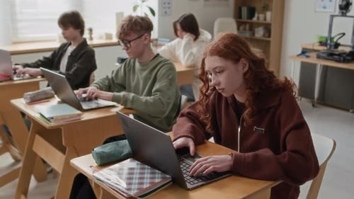 Group of Teenagers Using Laptops While Studying at Their Desks