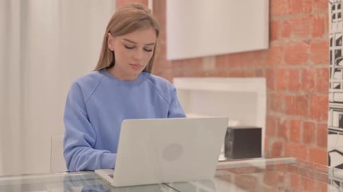 Woman Works on Laptop at Glass Table Indoors