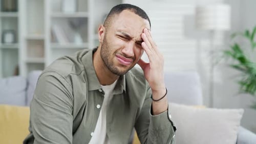 Adult Man with Headache Massaging Temple