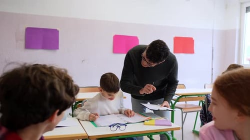 Teacher Helping Students in Elementary School Classroom