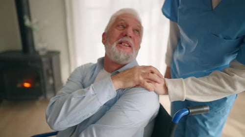 Elderly Man with Caregiver Holding Hand Indoors
