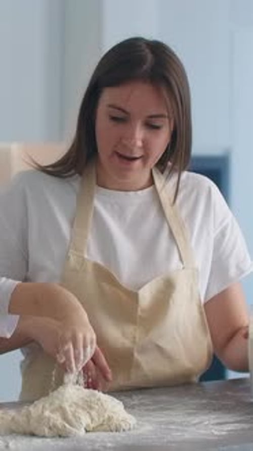 Mother and Child Kneading Dough Together in Bright Kitchen Wearing Aprons and Sharing a Joyful