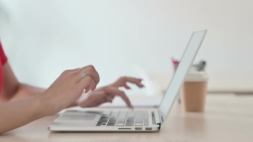 Side View of Young Blonde Woman Typing on Laptop Keyboard