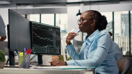 Forex Expert in Office Looking Over Candlestick Charts on Screen